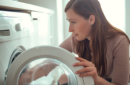 A woman confidently operating a dryer vent cleaning machine, ensuring the proper maintenance of the ventilation system.